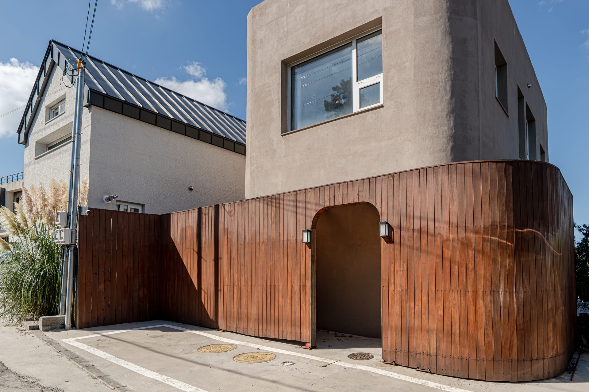 Exterior of Daam Daam Stay — curved cedar cladding and rendered concrete