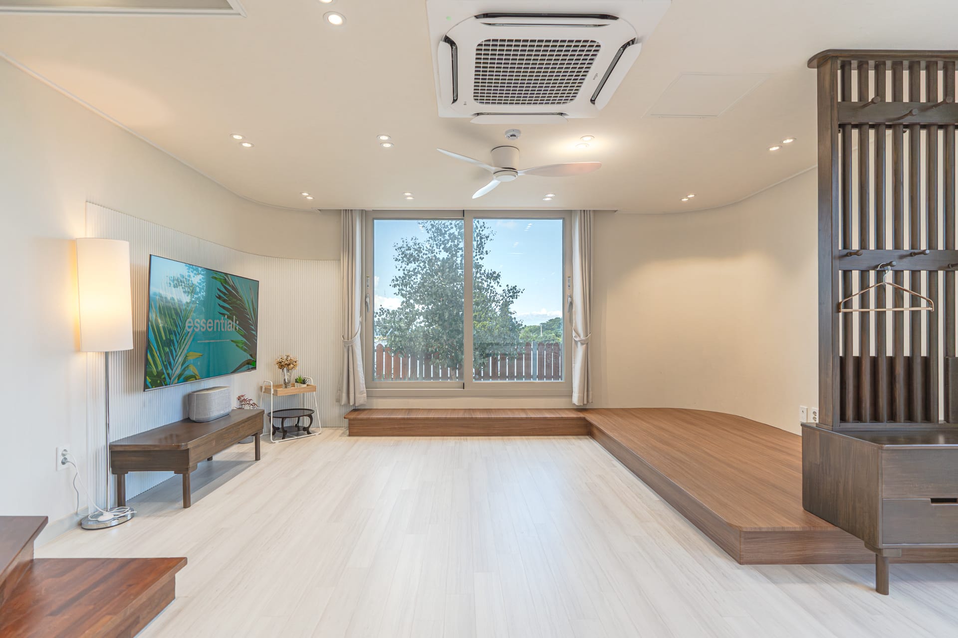 Raised wooden platform lounge with a large screen and garden view