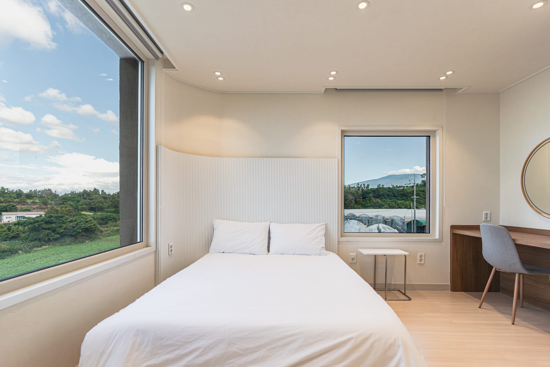Bedroom with a corner window framing Hallasan mountain