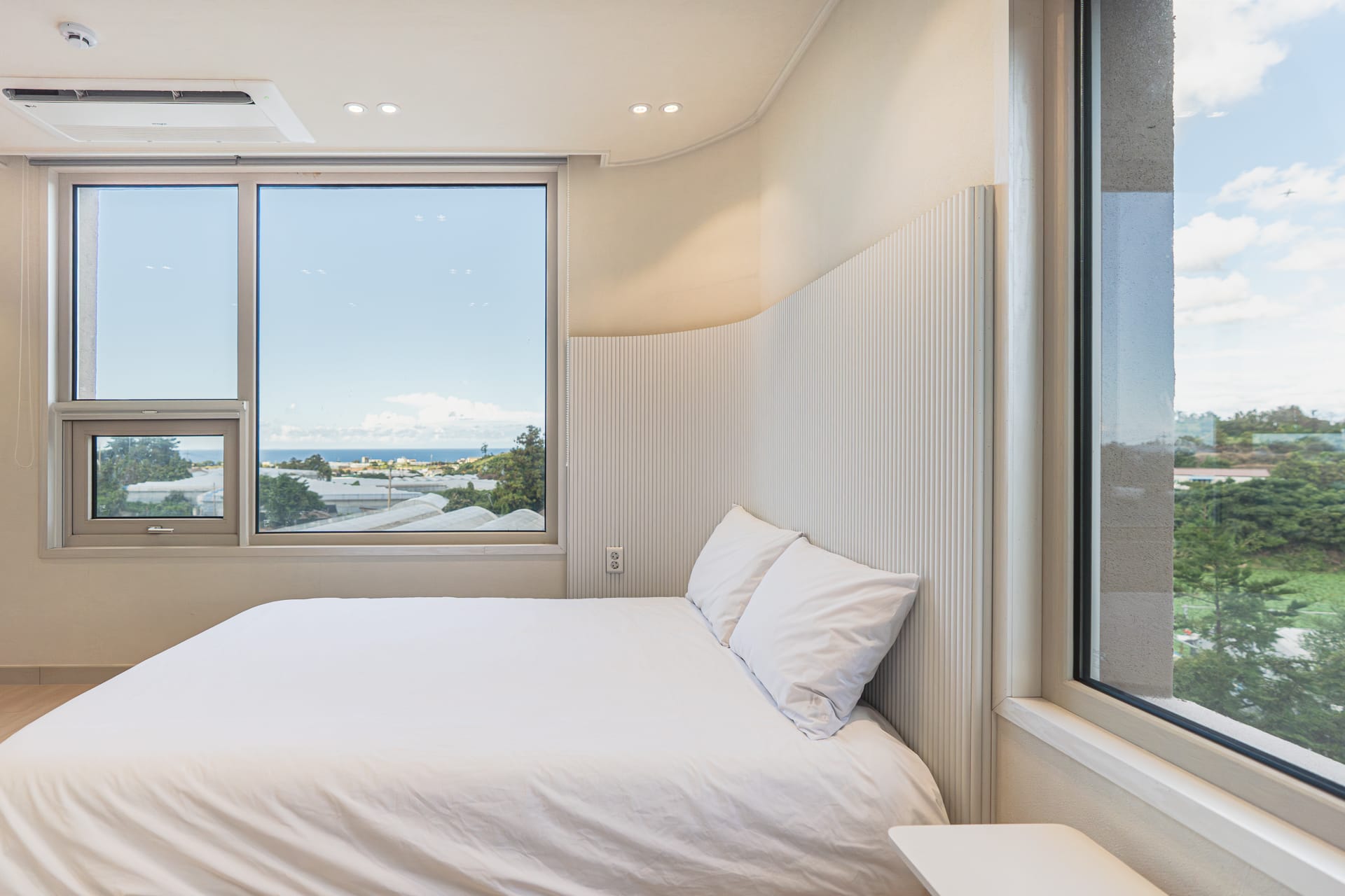 Bedroom with wide windows looking out to the sea